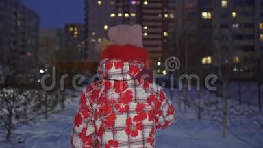 一个戴着冬帽和羽绒服的年轻女孩在冬日的街上走在傍晚的<strong>背景</strong>里。冬<strong>日漫</strong>步少女